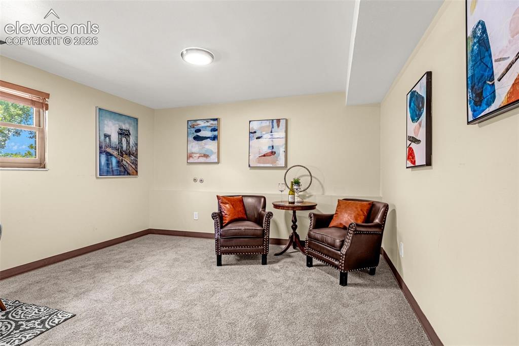 Image 28 of 38: Carpeted room featuring a single window with blinds, light-toned walls, and