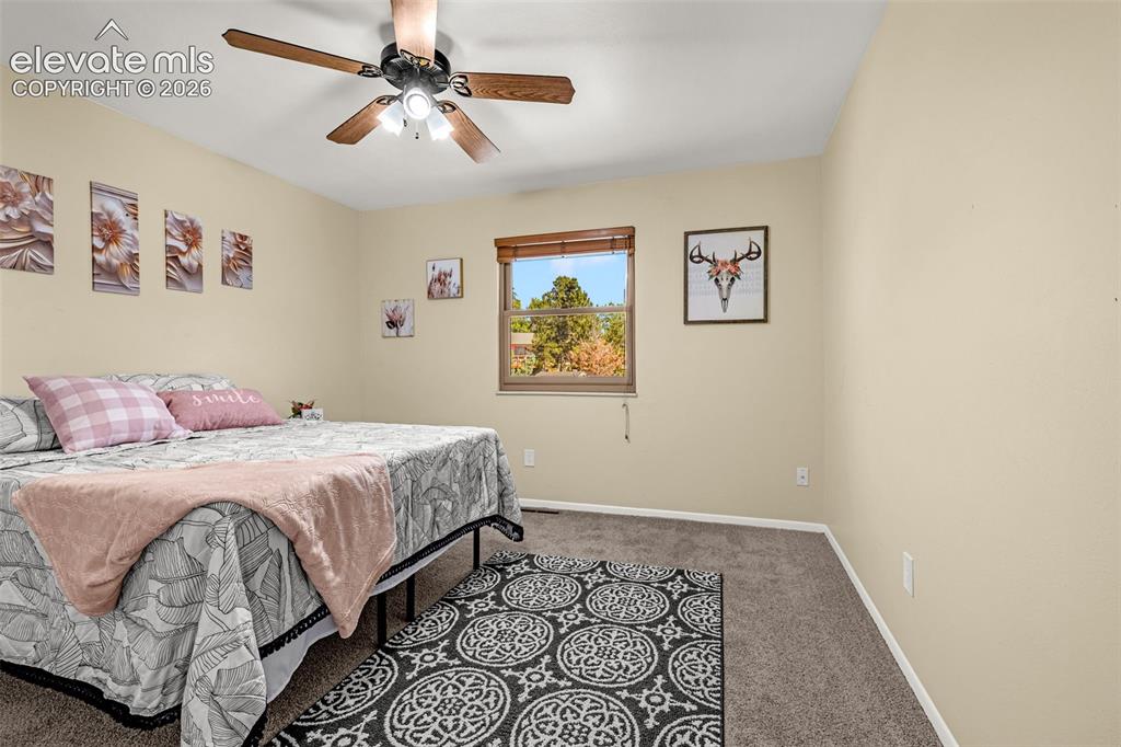 Image 30 of 38: Carpeted room featuring a ceiling fan with integrated lighting, a window wi
