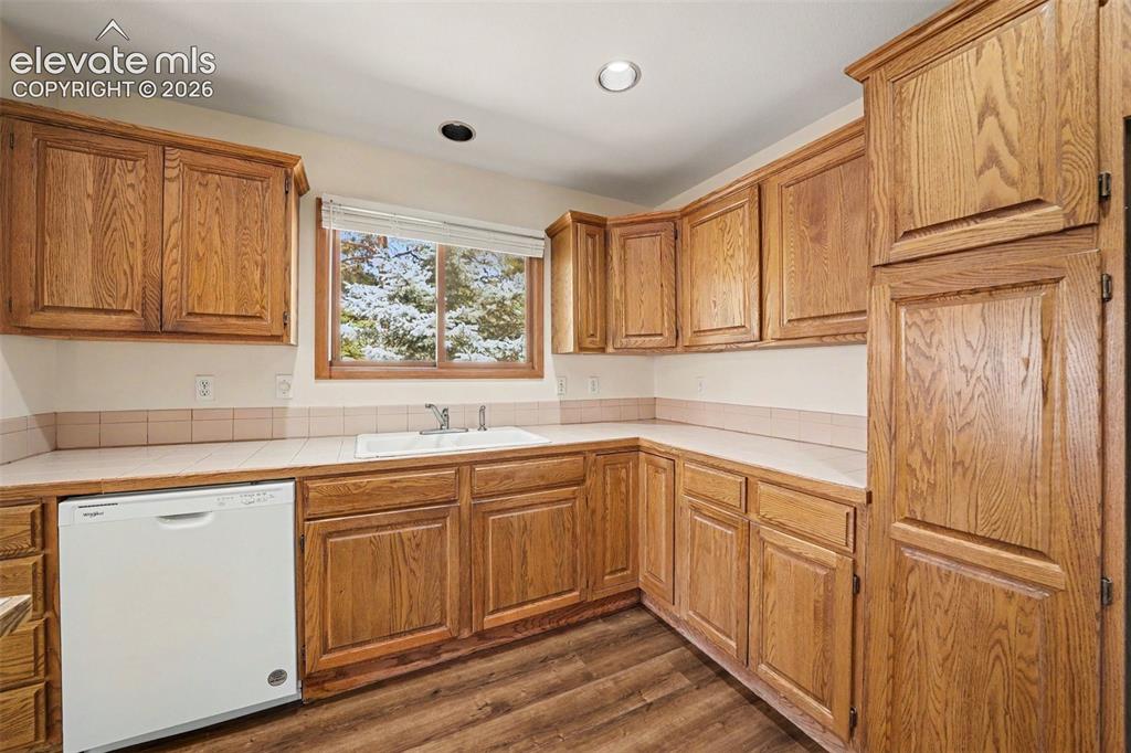 Image 12 of 47: L-shaped kitchen with new LVP flooring, ample cabinetry, and an integrated 