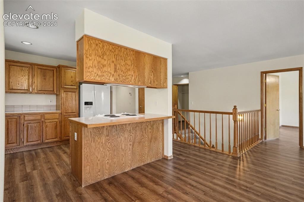 Image 13 of 47: Kitchen with new LVP flooring, built-in cabinetry, white appliances, and a 