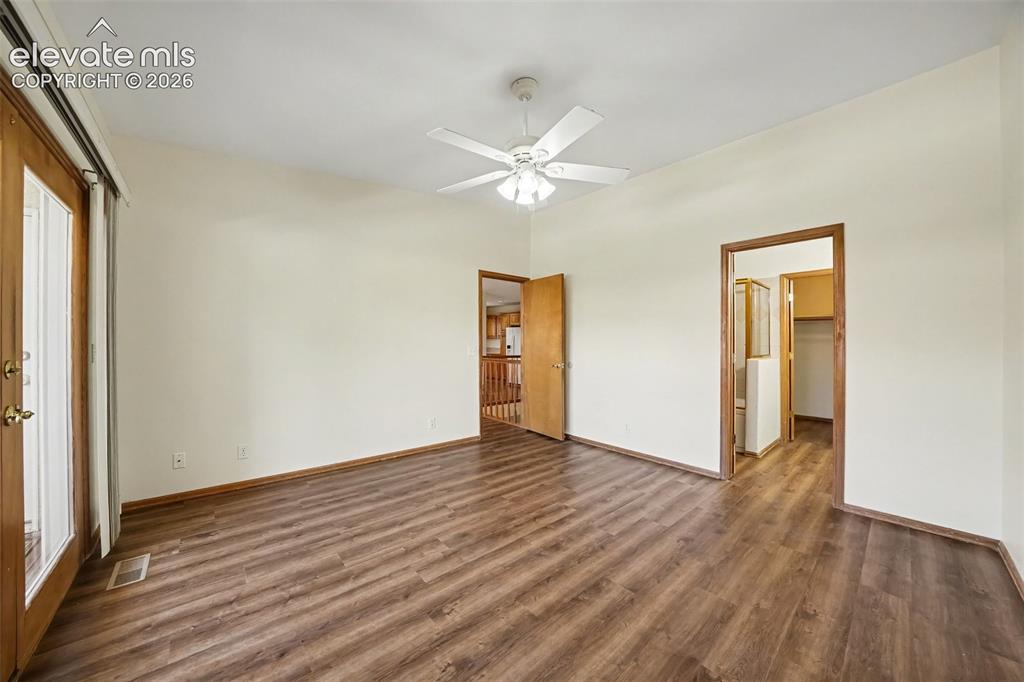 Image 20 of 47: New paint and LVP flooring, ceiling fan, and doors to balcony