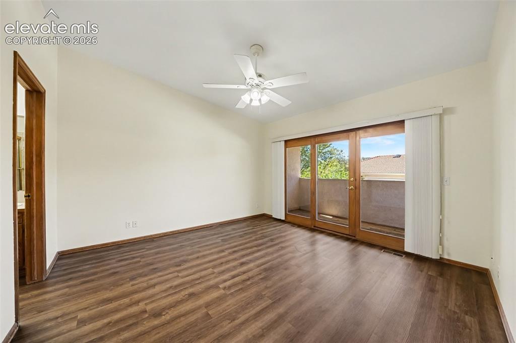 Image 22 of 47: New paint and LVP flooring, ceiling fan, and doors to balcony