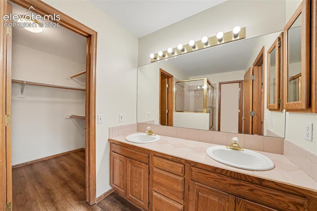 Image 23 of 47: Double vanity with integrated sinks, expansive wall mirror, and overhead st