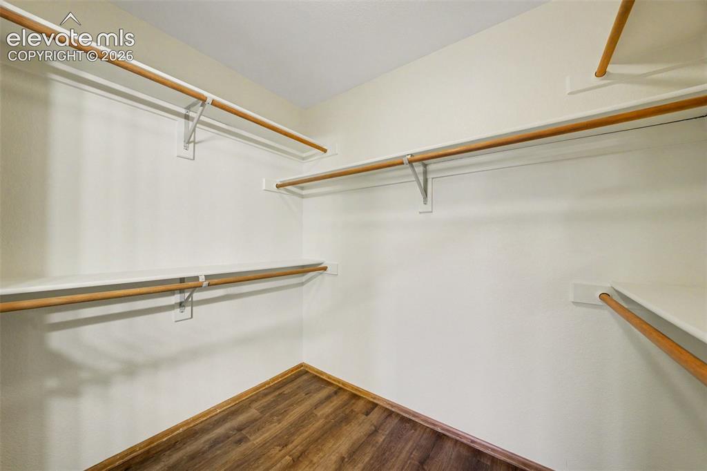 Image 25 of 47: New LVP flooring with multiple built-in shelving units and hanging rods