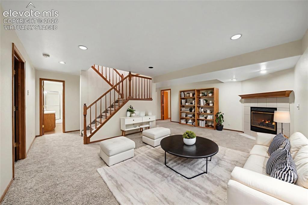 Image 27 of 47: Virtually staged. Fireplace with tile surround and wood mantle, recessed li