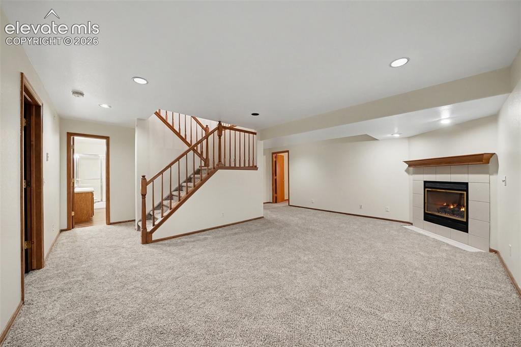 Image 28 of 47: Spacious room featuring light gray carpet, recessed lighting, a fireplace w