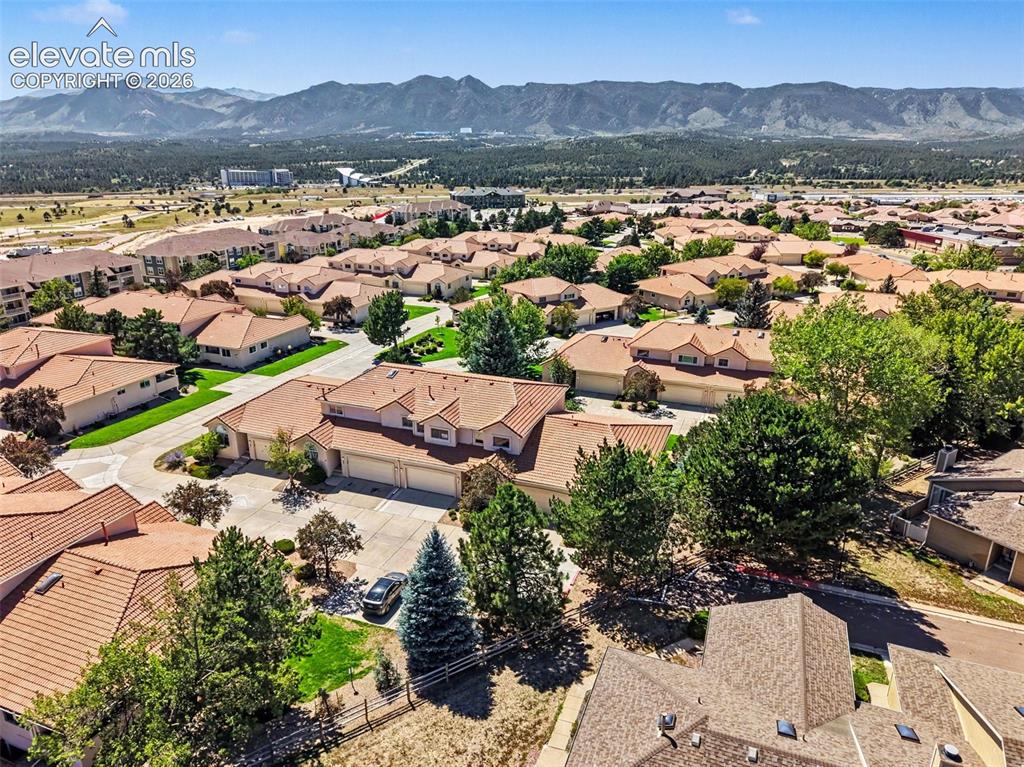 Image 39 of 47: Expansive residential community with terracotta-style roofs, mature landsca