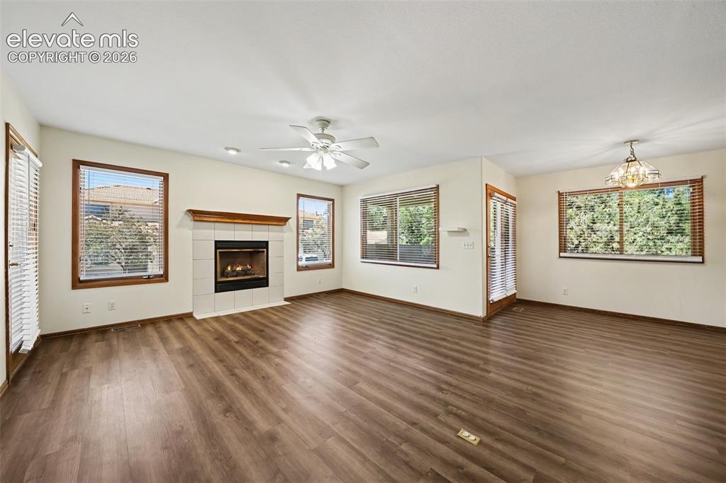 Image 4 of 47: Spacious room featuring new LVP  flooring, a tile-surround fireplace with a