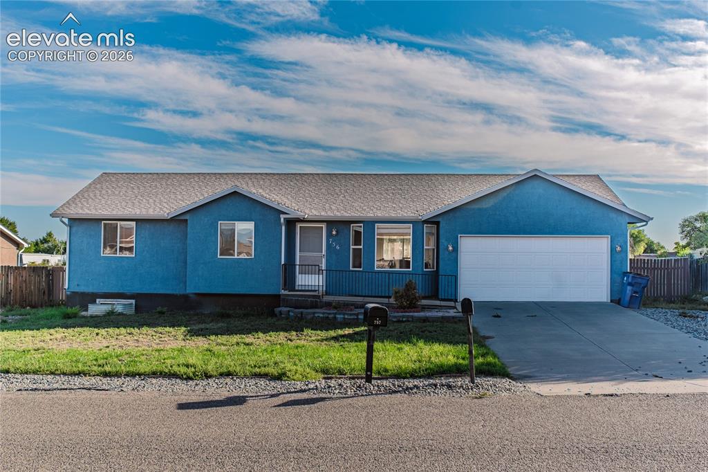 Caption: Single-story residence with a light blue exterior, a gabled roof, an attached two-car garage, a conc