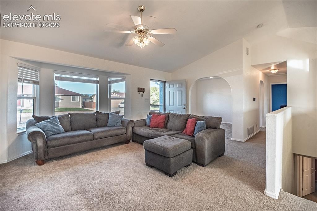 Image 3 of 30: Vaulted ceilings with a ceiling fan, bay windows, arched doorways, and carp