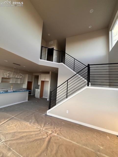Image 3 of 14: Stairway featuring a high ceiling and baseboards