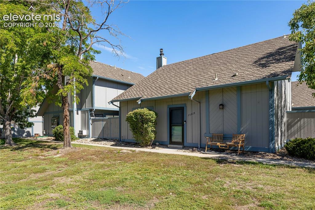 Image 1 of 28: Exterior featuring vertical siding, a pitched shingle roof, a chimney stack