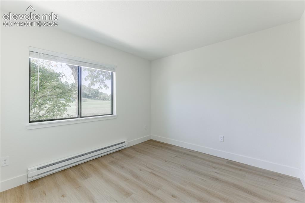 Image 12 of 28: Neutral-toned wood-finish flooring, crisp white walls, and a large horizont