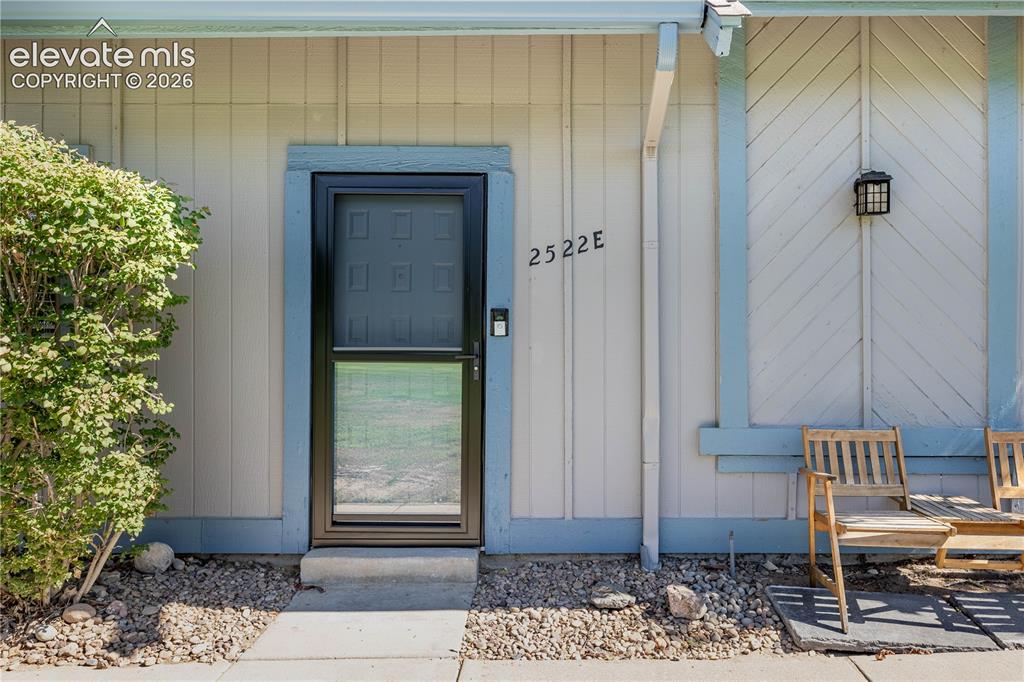 Image 2 of 28: Exterior entry featuring board-and-batten siding, a black-framed storm door