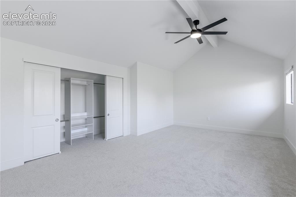 Image 20 of 28: Vaulted ceilings with exposed beams, ceiling-mounted light fixture with fan