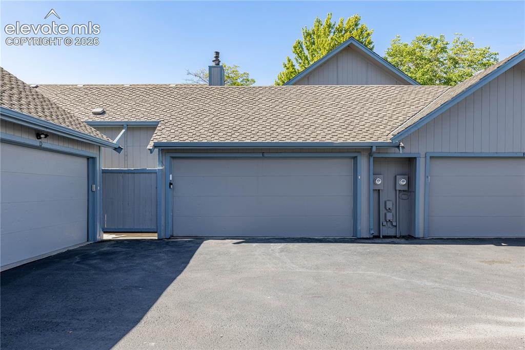 Image 25 of 28: Exterior view featuring dual-car garage bays, vertical panel siding, asphal