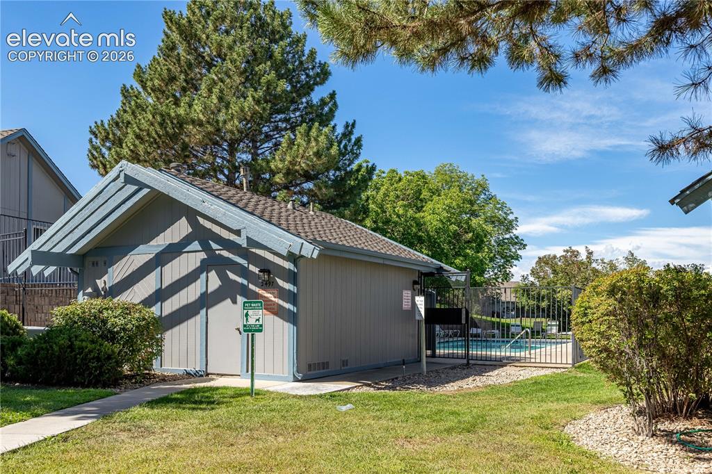 Image 28 of 28: Community building with wood-paneled siding, asphalt shingle roof, attached