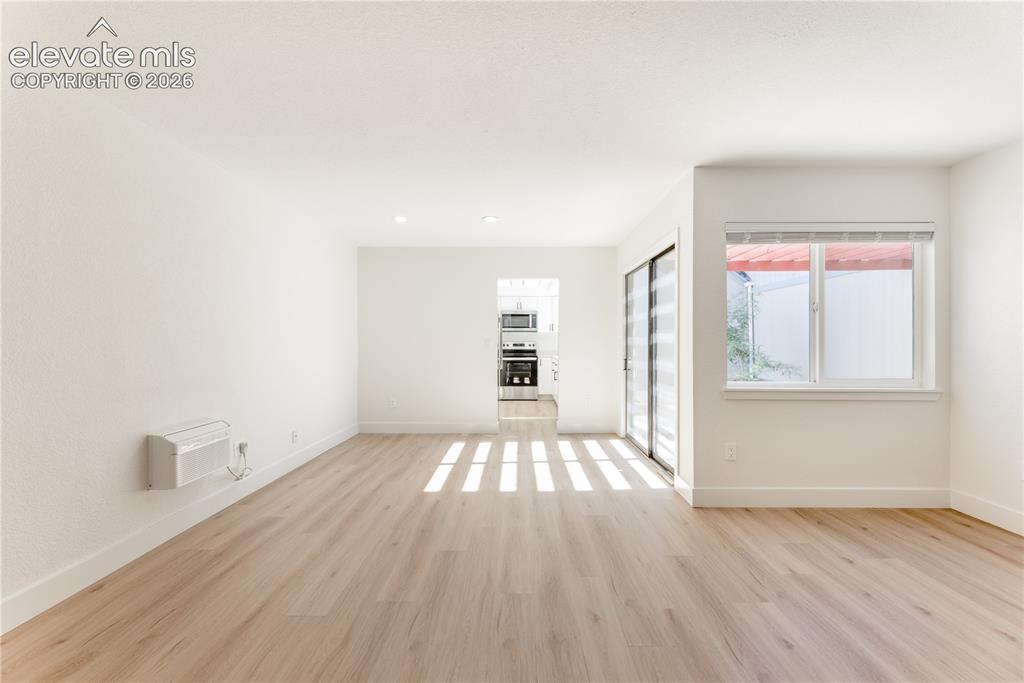 Image 4 of 28: Interior space featuring wood-finish flooring, recessed lighting, sliding g