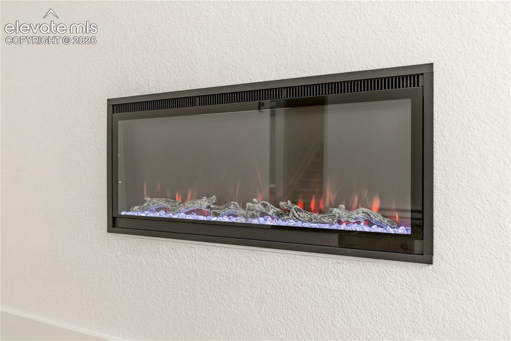 Image 5 of 28: Wall-mounted electric fireplace featuring a rectangular black frame, glass 