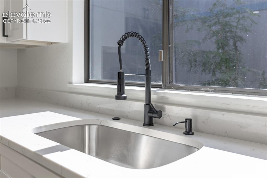 Image 9 of 28: Undermount stainless steel kitchen sink featuring a matte black pull-down s
