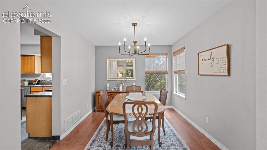 Image 13 of 30: Formal dining area featuring rich wood-finish flooring and a contemporary c