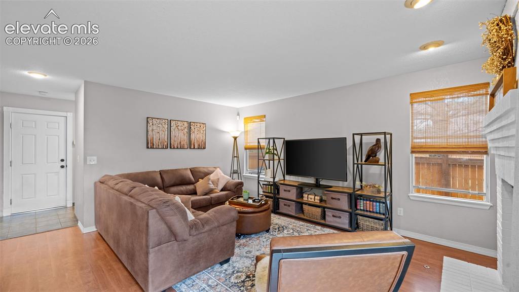 Image 16 of 30: Bright living area featuring wood-finish flooring and light gray walls