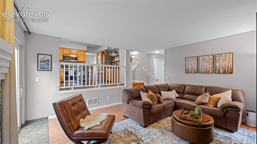 Image 17 of 30: Open-concept living area featuring light gray walls, wood-finish flooring,