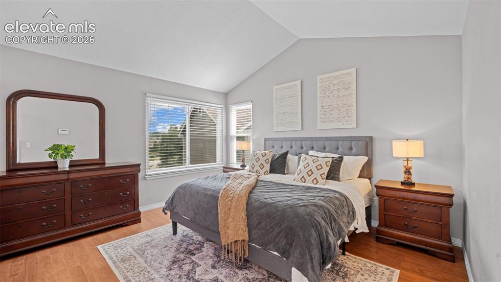 Image 22 of 30: Vaulted ceilings enhance this room featuring wood-finish flooring