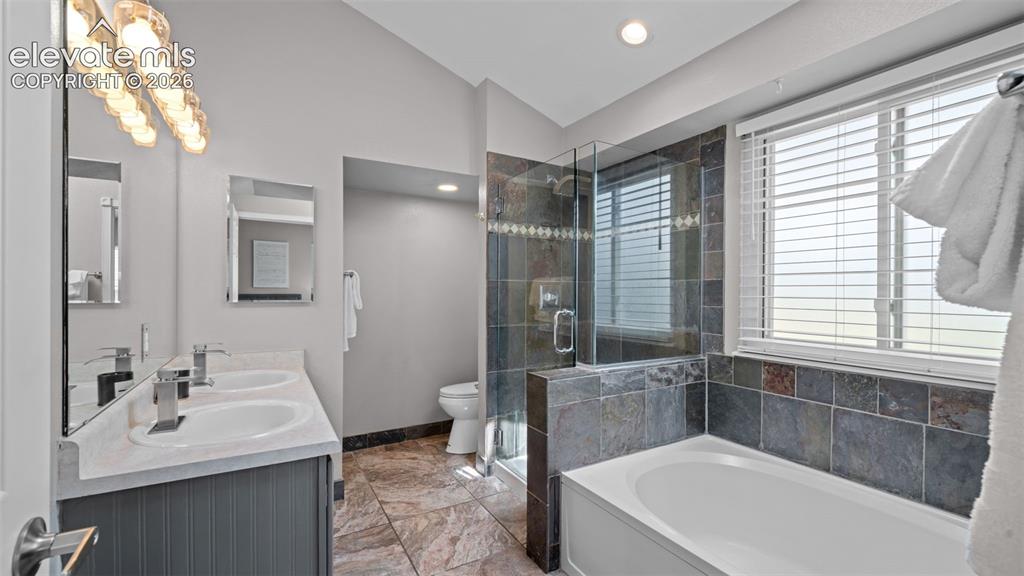 Image 24 of 30: Bathroom featuring dual vanity sinks with modern faucets, a built-in soakin