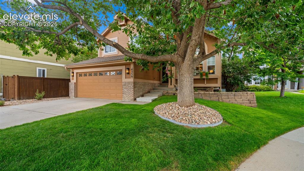 Image 3 of 30: Two-story residence featuring a two-car garage with carriage-style doors, s