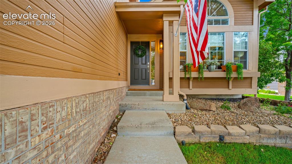 Image 4 of 30: Front exterior featuring horizontal siding, brick accents, and a covered en