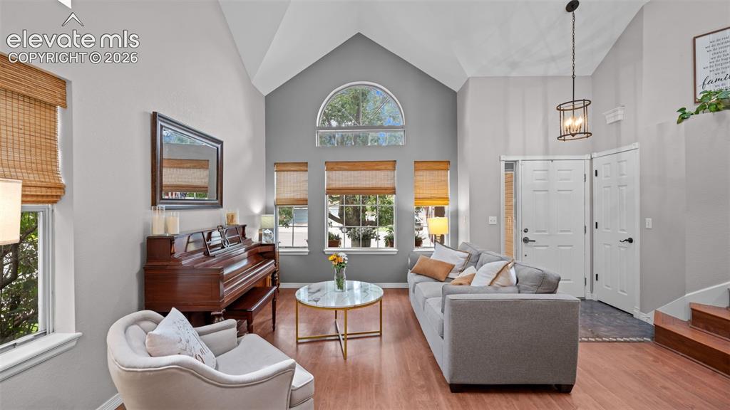 Image 5 of 30: Vaulted ceilings with an arched window highlight the living area, featuring