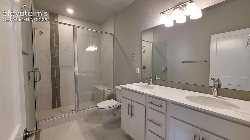 Image 15 of 36: Primary Bathroom with double vanities, quartz countertop, shower with bench