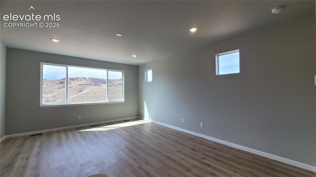 Image 5 of 36: Living Room with LVP flooring, LED Lighting, and an abundance of natural li