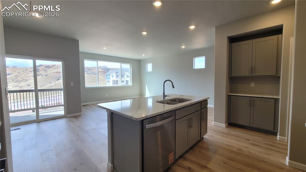 Image 7 of 29: Kitchen with Quartz countertops, pantry, large island, and stainless steel 