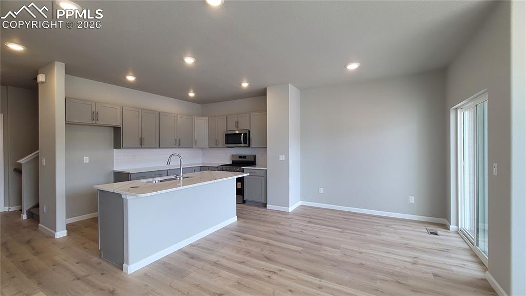 Image 8 of 29: Kitchen with Quartz countertops, pantry, large island, and stainless steel 