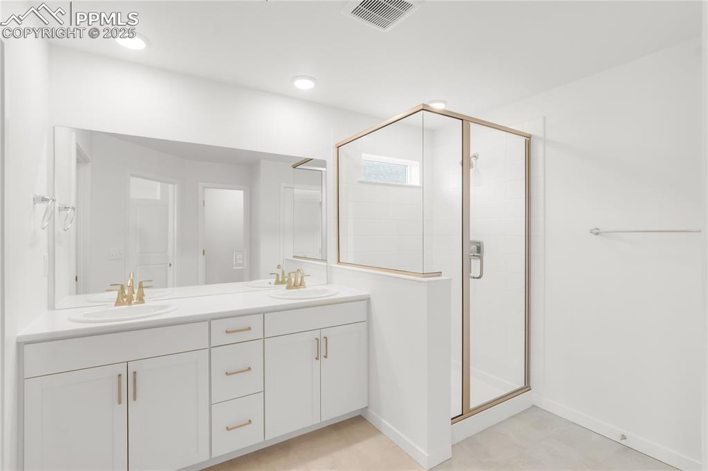 Image 12 of 39: Bathroom with double vanity and a shower stall