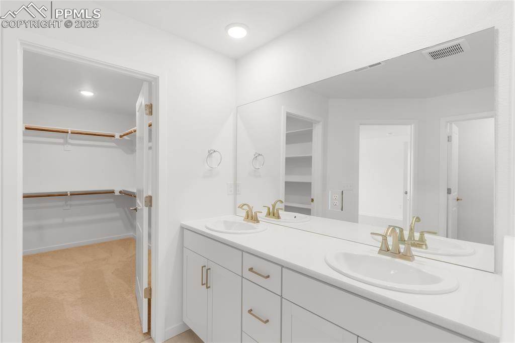 Image 13 of 39: Bathroom featuring double vanity and a spacious closet