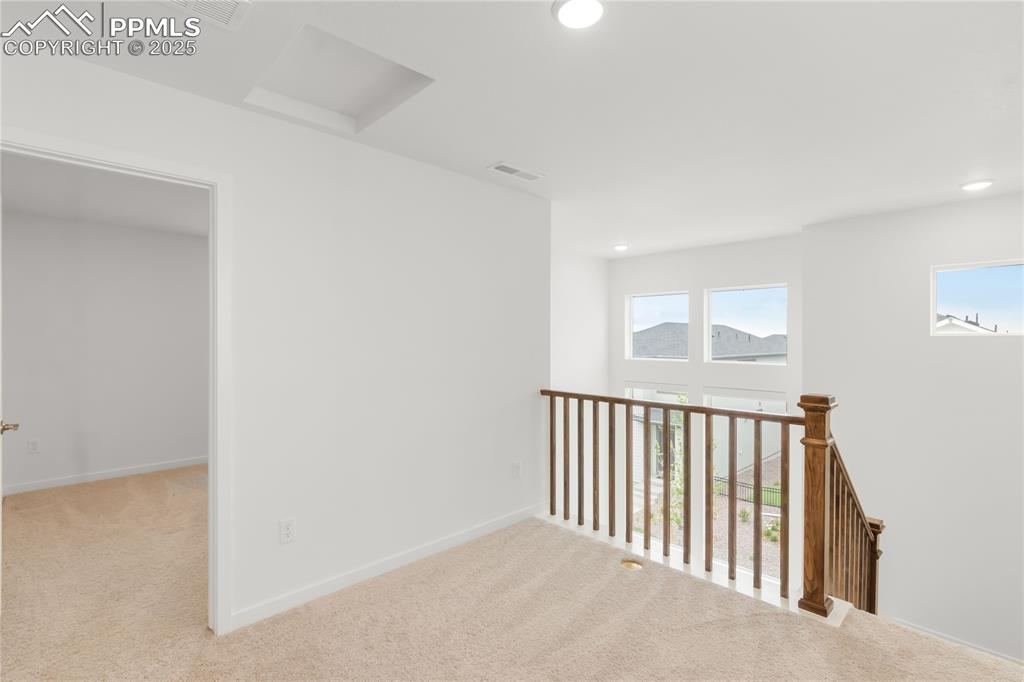 Image 17 of 39: Hallway with healthy amount of natural light, carpet floors, and recessed l