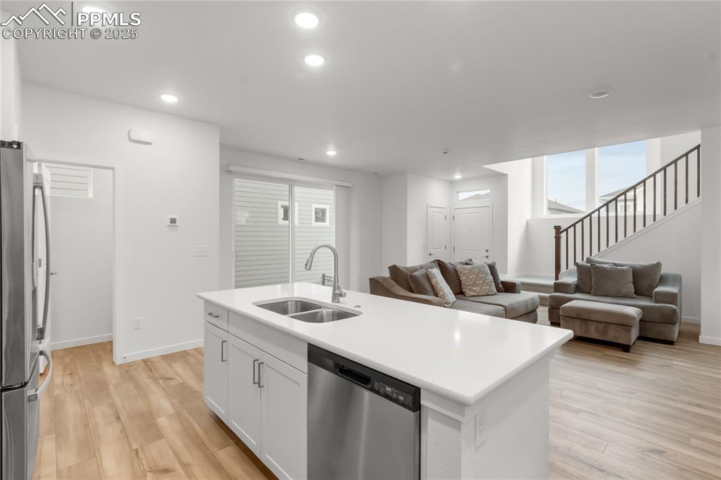Image 34 of 39: Kitchen with appliances with stainless steel finishes, light wood-type floo