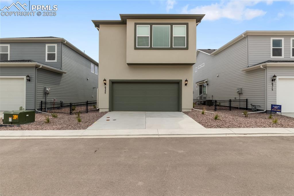 Image 38 of 39: Traditional home featuring stucco siding, concrete driveway, and a garage