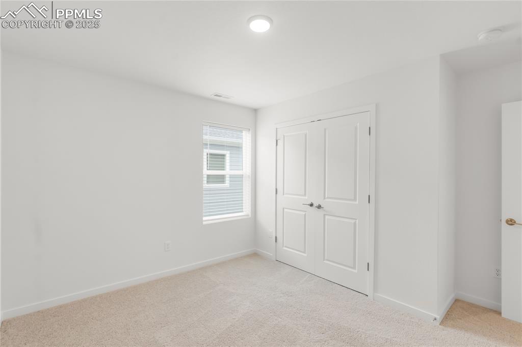 Image 6 of 39: Unfurnished bedroom featuring light colored carpet and a closet