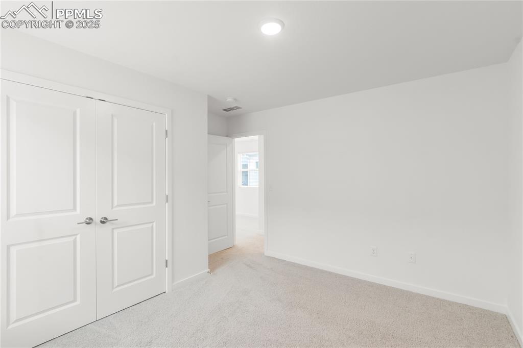 Image 7 of 39: Unfurnished bedroom featuring light carpet and a closet