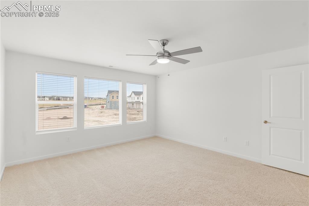Image 8 of 39: Spare room featuring light colored carpet and ceiling fan