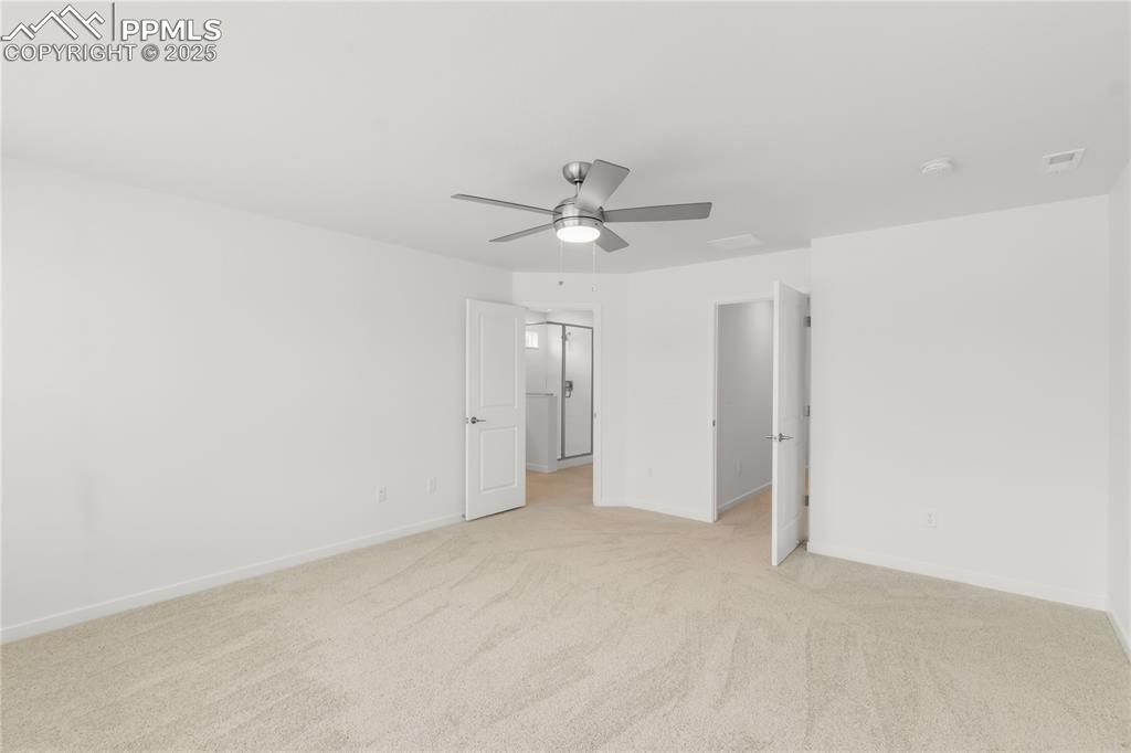 Image 9 of 39: Unfurnished bedroom with light colored carpet and a ceiling fan