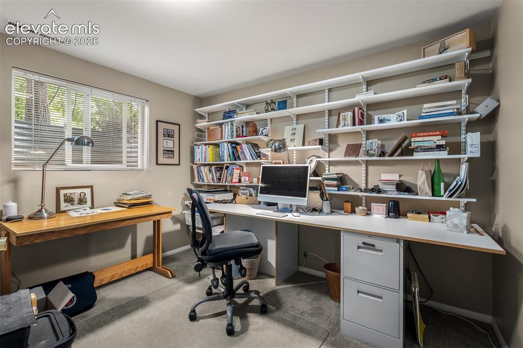 Image 43 of 50: Office with built-in shelves and closet