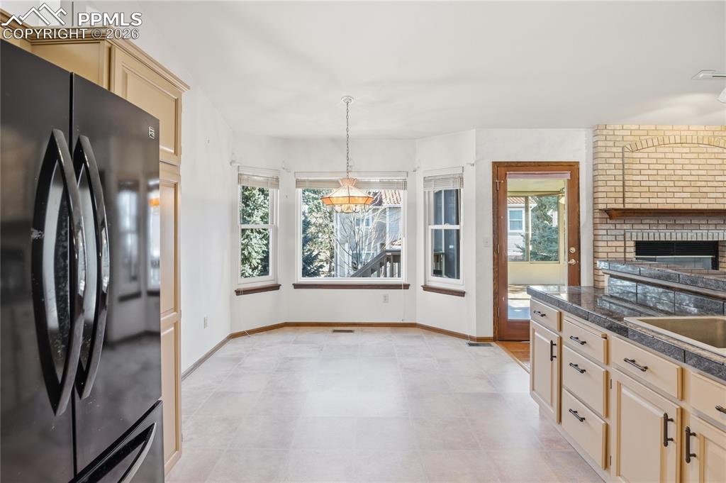 Image 13 of 47: Kitchen with freestanding refrigerator, light brown cabinetry, healthy amou