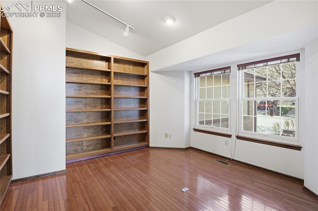 Image 19 of 47: Unfurnished room with vaulted ceiling, hardwood / wood-style floors, and ra