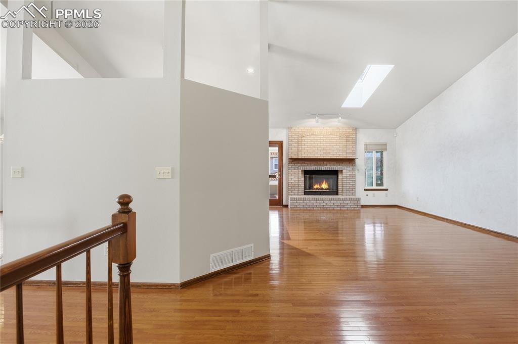 Image 5 of 47: Unfurnished living room featuring a skylight, light wood finished floors, a