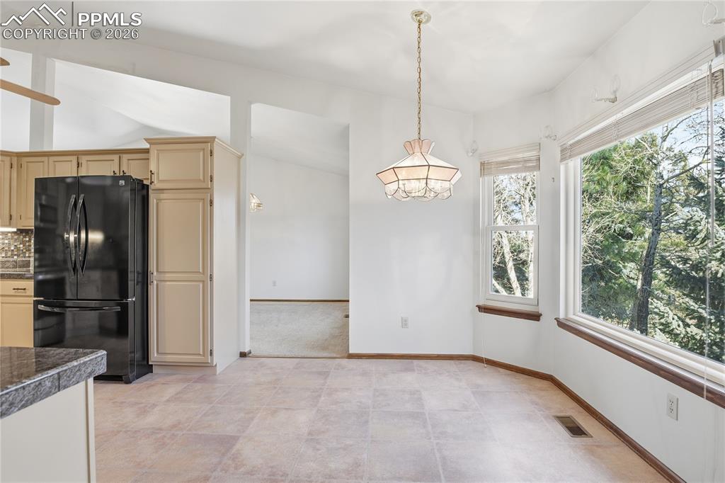 Image 9 of 47: Kitchen featuring freestanding refrigerator, decorative light fixtures, tas